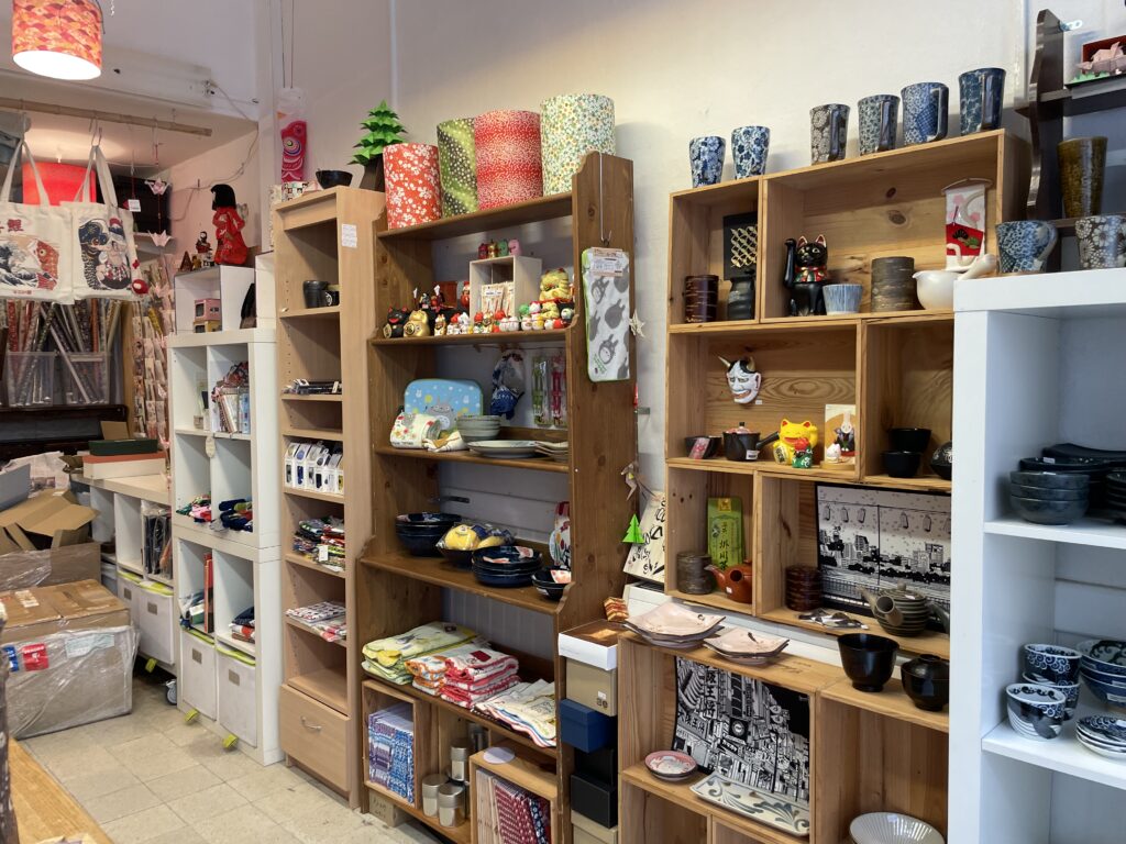 Étagères remplies de mugs, tasses, bols et objets décoratifs dans la boutique Le Temps Cerise