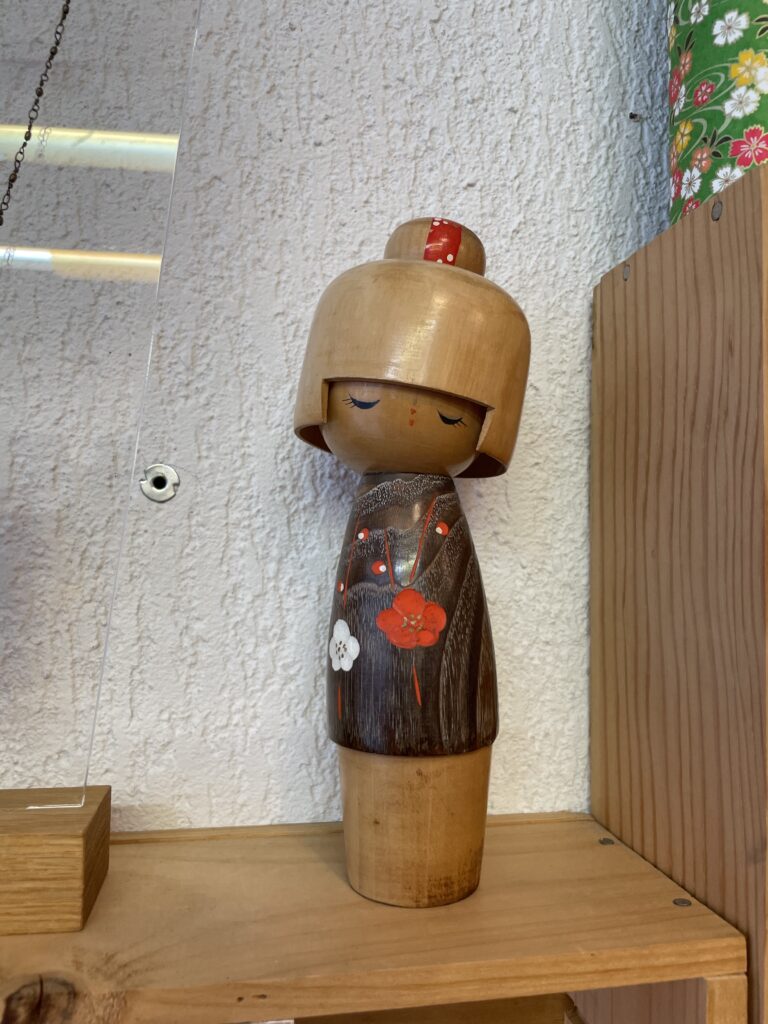 Poupée traditionnelle japonaise kokeshi en bois peint, avec fleurs décoratives