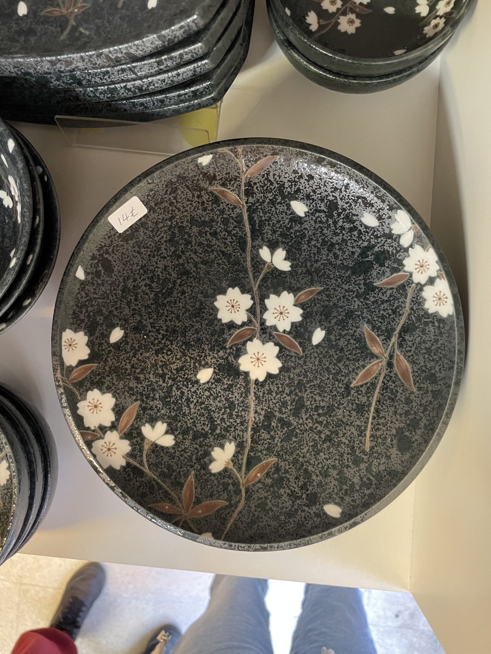 Grande assiette japonaise en céramique décorée de fleurs de cerisier blanches sur fond noir