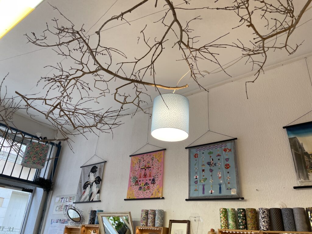 Décoration murale suspendue avec lanterne, branches naturelles et tableaux japonais – ambiance zen dans la boutique