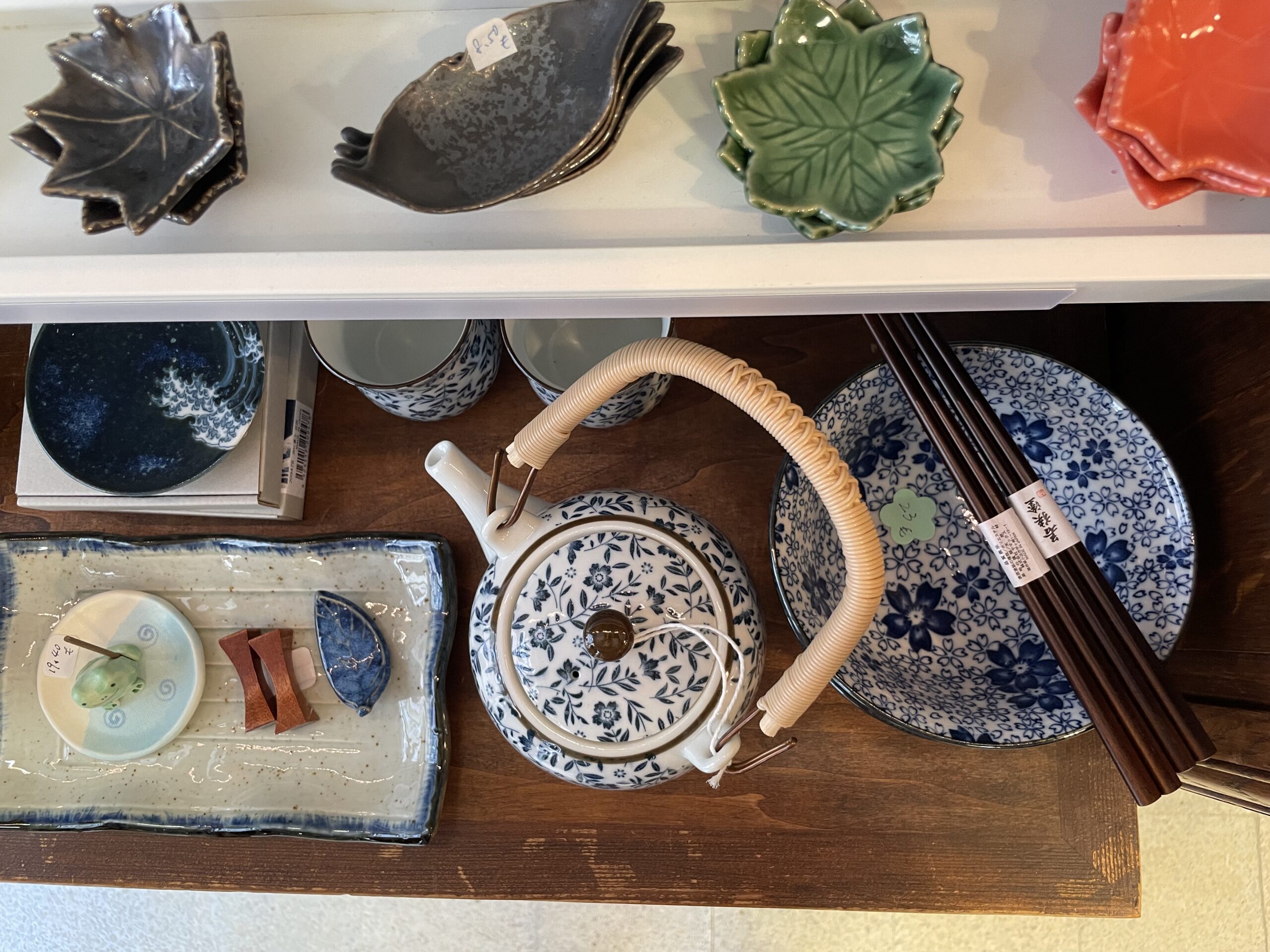 Vue de dessus d’une théière japonaise avec vaisselle assortie et baguettes en bois