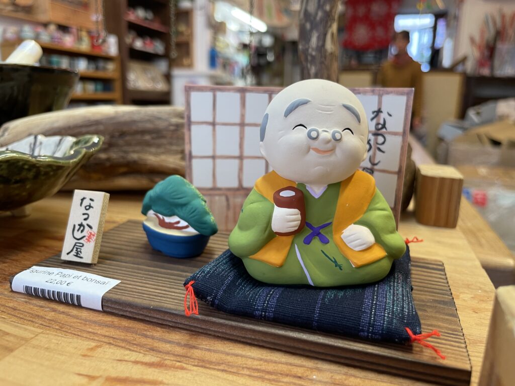 Petite statuette de moine japonais assis avec tasse de thé, décor zen et traditionnel